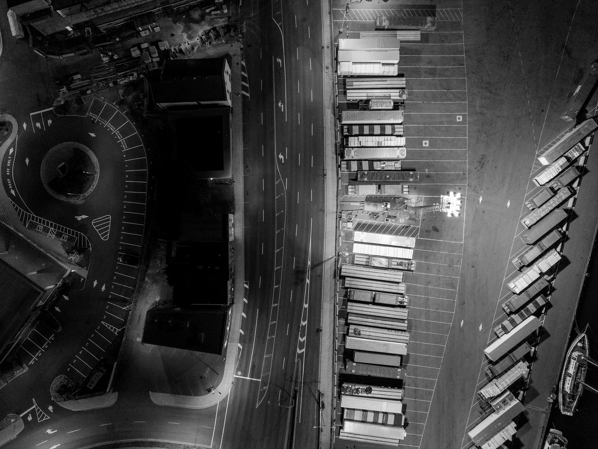 Vue aérienne nocturne de remorques alignées le long d’un quai