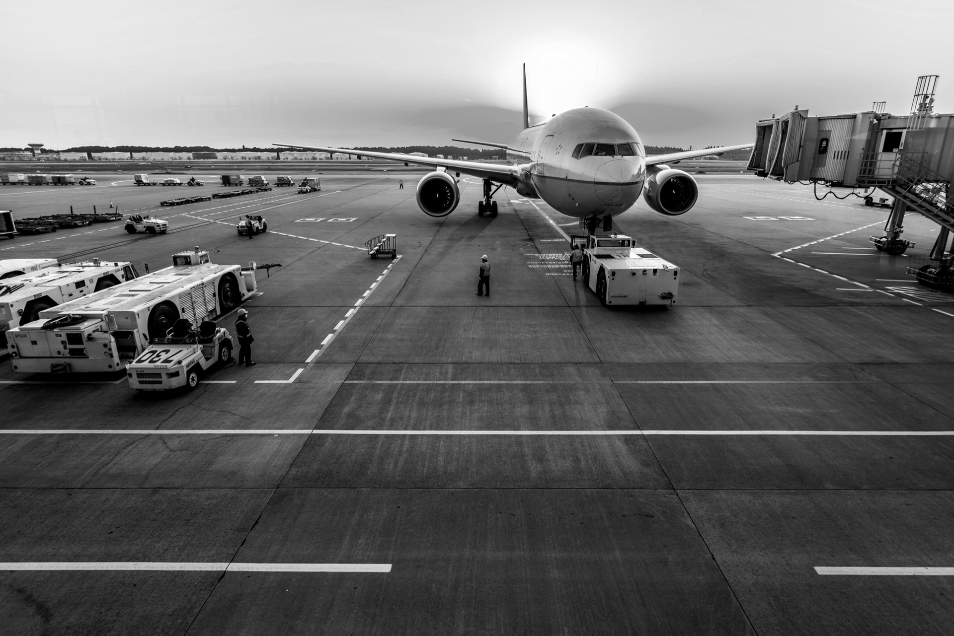 Avion à quai sur le tarmac, entouré d’engins de piste